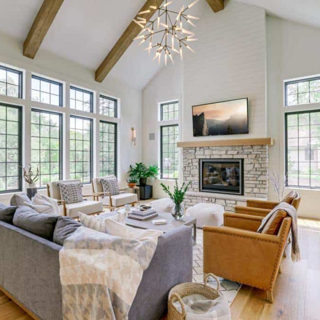 vaulted ceiling with beams fireplace lots of big windows and open concept floor plan living room
