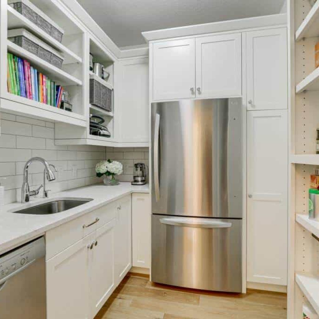 walk in pantry with refrigerator sink dishwasher and lots of cabinets for storage