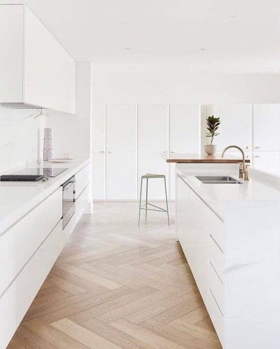 modern all white kitchen with no hardware cabinets and natural white oak herringbone flooring