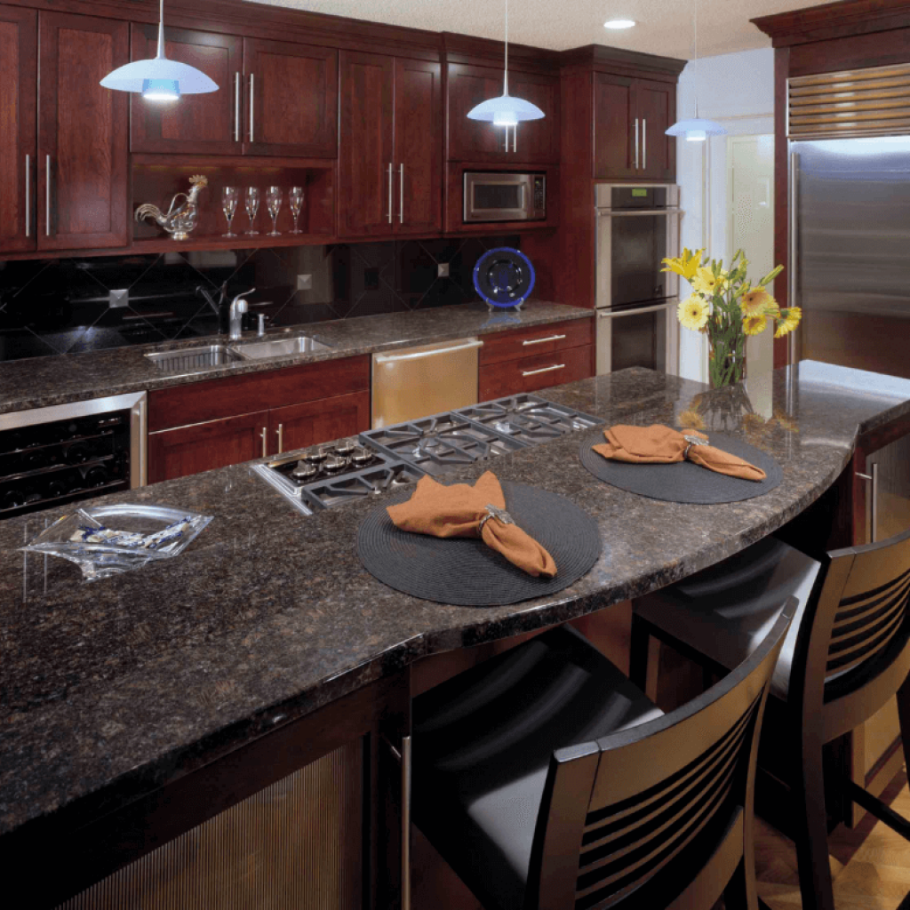 A beautiful tan and brown polished granite countertop that is set on gorgeous cherry cabinets. Stainless steel appliances and chrome fixtures complete the traditional kitchen style.