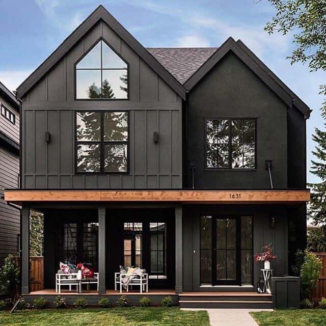 Delightful dark modern two story farmhouse with just a hint of contrast in the cedar beam. Large black windows and dutch doors bring the outdoors indoor and create an inviting family home. House by Trickle Creek Custom Homes. #downleahslane #blackhouse #blackhome #darkexterior #darkhouse #twostory #blackwindows #cedar #exteriorideas #exteriordesign #dreamhome #boardandbatten