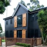 Pairing a black exterior with natural cedar wood shutters provides a great contrast to this dark modern farmhouse. Plus the sliding barn doors on the first floor are amazing! via The Essential Detail. #downleahslane #blackhouse #darkhouse #blackexterior #blackhouse #cedarshutters #slidingbarndoors #cedar #modernfarmhouse #twostoryhouse #dreamhouse